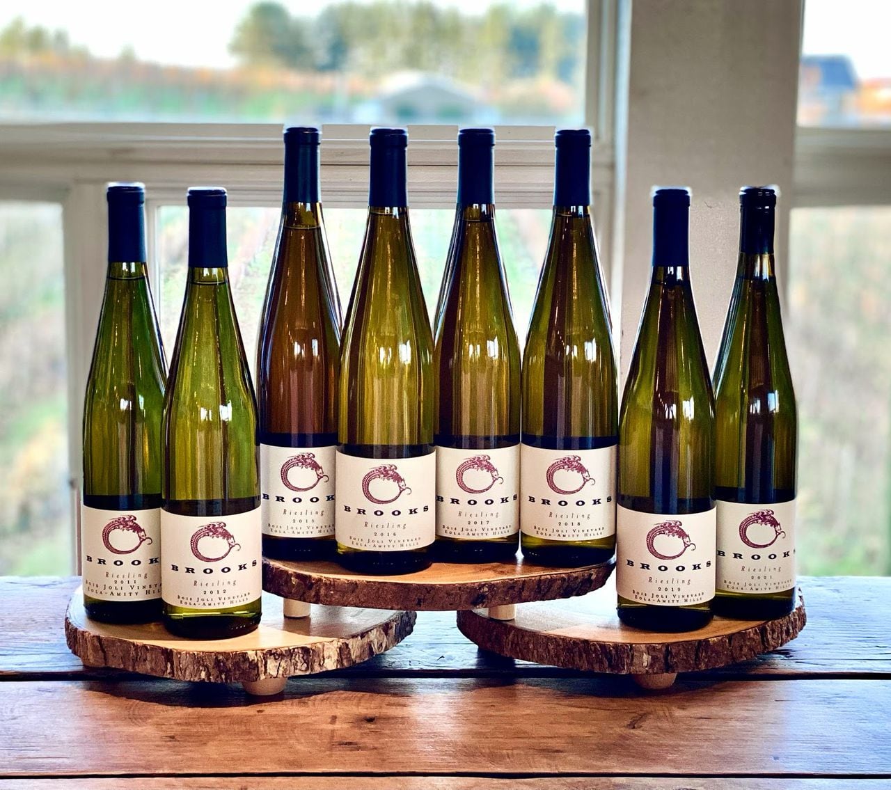 Eight bottles of wine sit on a winery tasting room bar.